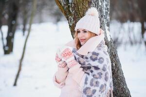 schönes Winterporträt der jungen Frau in der schneebedeckten Winterlandschaft foto