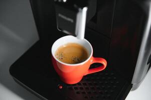 modern Espresso Kaffee Maschine mit ein Tasse im Küche foto