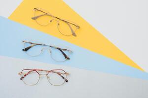 modisch modisch Augen Brille zum Korrektur von Vision auf ein bunt Hintergrund, geometrisch Hintergrund von Papier von Pastell- Farben foto