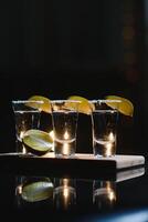 lecker Alkohol trinken Cocktail Tequila mit Limette und Salz- auf beschwingt dunkel Hintergrund. Nahaufnahme. foto