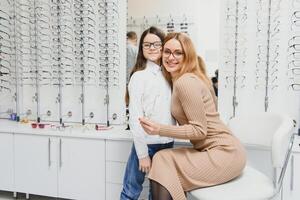 Mutter und Mädchen beim Optiker Geschäft. foto
