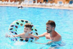 Vater und Sohn haben Spaß im Schwimmen Schwimmbad. Familie Ferien foto