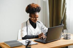 afrikanisch weiblich Arzt Beratung geduldig machen online Webcam Video Anruf auf Laptop. schwarz Frau Therapeut Videokonferenzen im Fernbedienung Computer Gesundheitswesen Telemedizin virtuell Plaudern. Telegesundheit Videoanruf foto