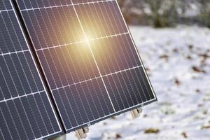 Solar- Paneele mit Schnee auf Boden auf ein gut belichtet Mauer von ein Individuell Haus, Herstellung Ersparnisse folgenden das Energie Krise, Öko-Bürger Geste, Grün Energie foto