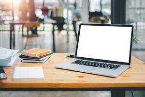 ein organisiert Arbeit Konfiguration mit ein Laptop mit ein leer Bildschirm, Notizbücher, und ein Pflanze auf ein hölzern Tabelle im ein hell Büro. foto