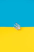 Dreizack Symbol von Ukraine Eisen Abzeichen auf das Hintergrund von das Blau Gelb Flagge foto