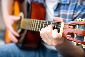 Hände von ein jung Mann spielen das Gitarre. Nahansicht. selektiv Fokus. foto