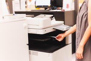 Frau Offizier ziehen Drucken Papier dokumentieren aus von funktional Büro Drucker. foto