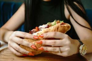 Frau Sitzung beim Tabelle mit Sandwich foto