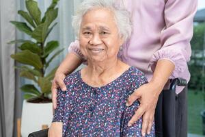 Pflegekraft Hilfe asiatisch Senior Frau auf Rollstuhl mit Liebe beim heim. foto