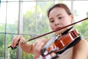 Konzept von Lernen klassisch Musik. Nahansicht von ein Frau spielen ein Violine klassisch Instrumente. Lehrer Lehren Studenten im Kunst Schule foto