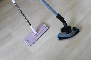 Reinigung Material und Vakuum Reiniger auf hölzern Boden. Zuhause Reinigung foto
