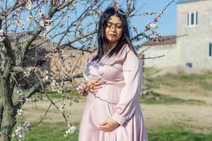 das schwanger Frau im das Park, schön Frau im das Park, schwanger Frau im Frühling foto