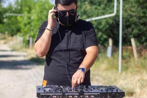 dj mit Kopfhörer und Rührgerät im das Park, das dj beim Arbeit foto