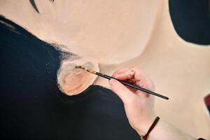 Frau Künstler zeichnet mit Farbe Bürste surreal Mädchen Porträt auf Weiß Segeltuch beim Kunst Gemälde foto