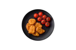 Köstliche, frische, knusprige Hühnernuggets auf dunklem Betonhintergrund foto
