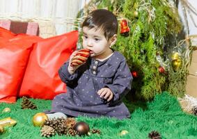 das wenig Kind spielen mit Weihnachten Dekorationen im Studio, wenig Kind mit Weihnachten Ball foto