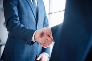 zwei selbstbewusste geschäftsleute, die sich während eines treffens im büro die hände schütteln, gruß- und partnerkonzept foto