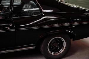 Sinsheim, Deutschland - 16. Oktober 2018 Technikmuseum. Luxus schwarz glänzendes Automobil von der Seite erfasst. Hinterrad und Rücksitze foto