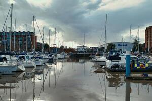 still Yachthafen mit Boote reflektiert im Ruhe Wasser unter ein dramatisch wolkig Himmel beim Dämmerung. foto