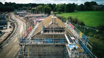 Antenne Aussicht von Konstruktion Seite? ˅ mit Gerüst und Gebäude Materialien, präsentieren Infrastruktur Entwicklung. foto