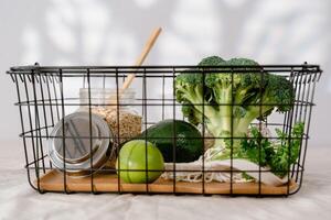 frisch Grün Gemüse im ein Metall Korb auf ein Licht Hintergrund. gesund Essen Konzept foto