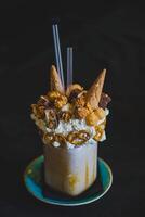 Milchshake mit ausgepeitscht Creme, Schokolade, Nüsse und Eis Sahne foto