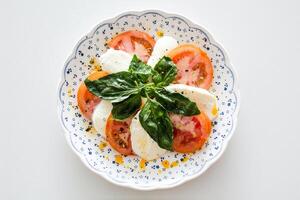 Caprese Salat mit Mozzarella, Tomaten und Basilikum Blätter foto