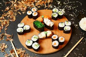 hölzern Teller mit Sushi und Essstäbchen foto