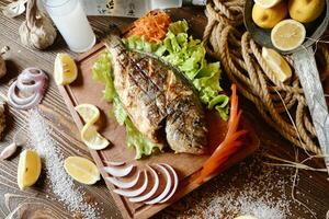 hölzern Schneiden Tafel mit frisch Fisch und Gemüse foto