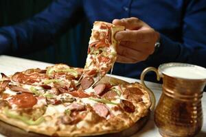 Person Schneiden ein Pizza mit ein Messer foto