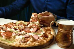 Nahansicht von ein Person genießen ein Scheibe von Pizza foto