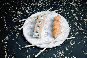 Weiß Teller mit Sushi und Essstäbchen foto