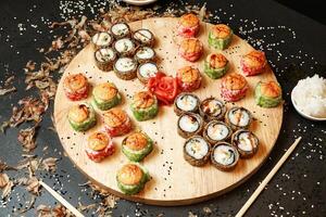 hölzern Teller bedeckt mit ein Fülle von Sushi Rollen foto