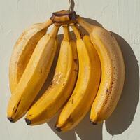 ai generiert Bündel von reif Bananen hängend von Haken foto