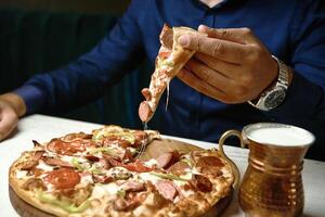 Mann Essen Pizza mit ein Scheibe fehlt foto