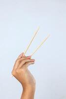 weiblich Hand halten Bambus Essstäbchen foto