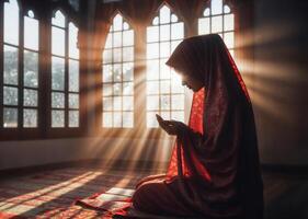 ai generiert ein Muslim Frau, bedeckt im ein rot Schleier, kniet im Gebet wie das Sonne Strahlen Filter durch ein in der Nähe Fenster. foto