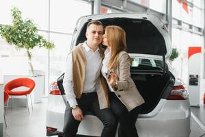 jung schön glücklich Paar Kauf ein Wagen. Mann Kauf Auto zum seine Ehefrau im ein Salon. Auto Einkaufen Konzept foto
