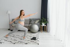 gesund Schwangerschaft Yoga und Fitness Konzept. jung schwanger Yoga Frau Arbeiten aus im Leben Zimmer Innere. foto