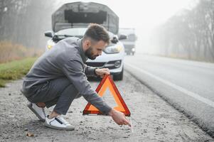 traurig Treiber haben Motor Problem Stehen in der Nähe von gebrochen Auto auf das Straße. Auto Nervenzusammenbruch Konzept foto