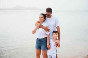 glückliche Familie, die am Strand spazieren geht foto