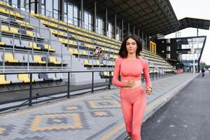 jung Frau Laufen während sonnig Morgen auf Stadion foto