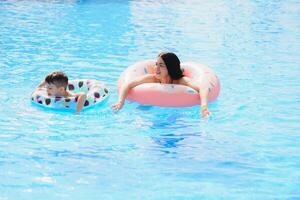 Mutter und Baby im draussen Schwimmen Schwimmbad von tropisch Erholungsort. Kind Lernen zu schwimmen. Mama und Kind spielen im Wasser. Familie Sommer- Ferien im exotisch Ziel. aktiv und gesund Sport zum Kinder. foto