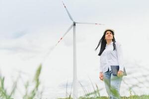 Frauen Ingenieur mit Tablette zum Arbeiten auf Seite? ˅ beim Wind Turbine Bauernhof foto