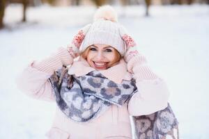 schönes Winterporträt der jungen Frau in der schneebedeckten Winterlandschaft foto