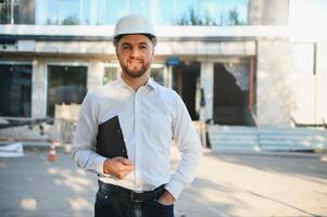 Ingenieur Nächster zu Gebäude Kräne. Konzept - - groß Konstruktion Projekt. Architekt leitet das Konstruktion Verfahren. Zeichnungen und Tablette im das Hände. foto