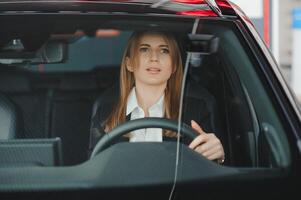 Foto von glücklich jung Frau Sitzung Innerhalb ihr Neu Wagen. Konzept zum Auto Vermietung.