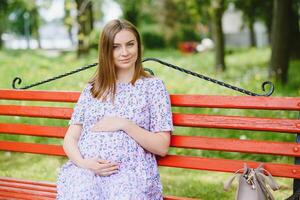 schöne schwangere Frau, die sich im Park entspannt foto
