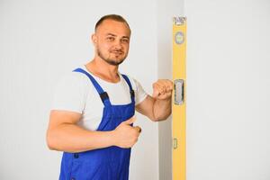 Handwerker prüfen das Ebenheit von das Mauer mit ein Geist eben. foto